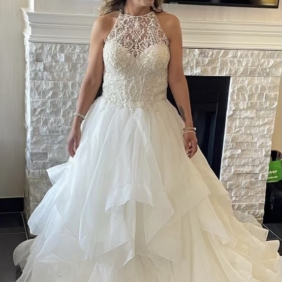 Image of a women in a wedding dress in front of a stone fireplace