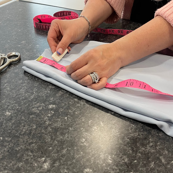 Measuring pants with a tape measure on a countertop